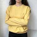 Model wearing soft yellow crew neck sweatshirt with cursive honey embroidery on chest