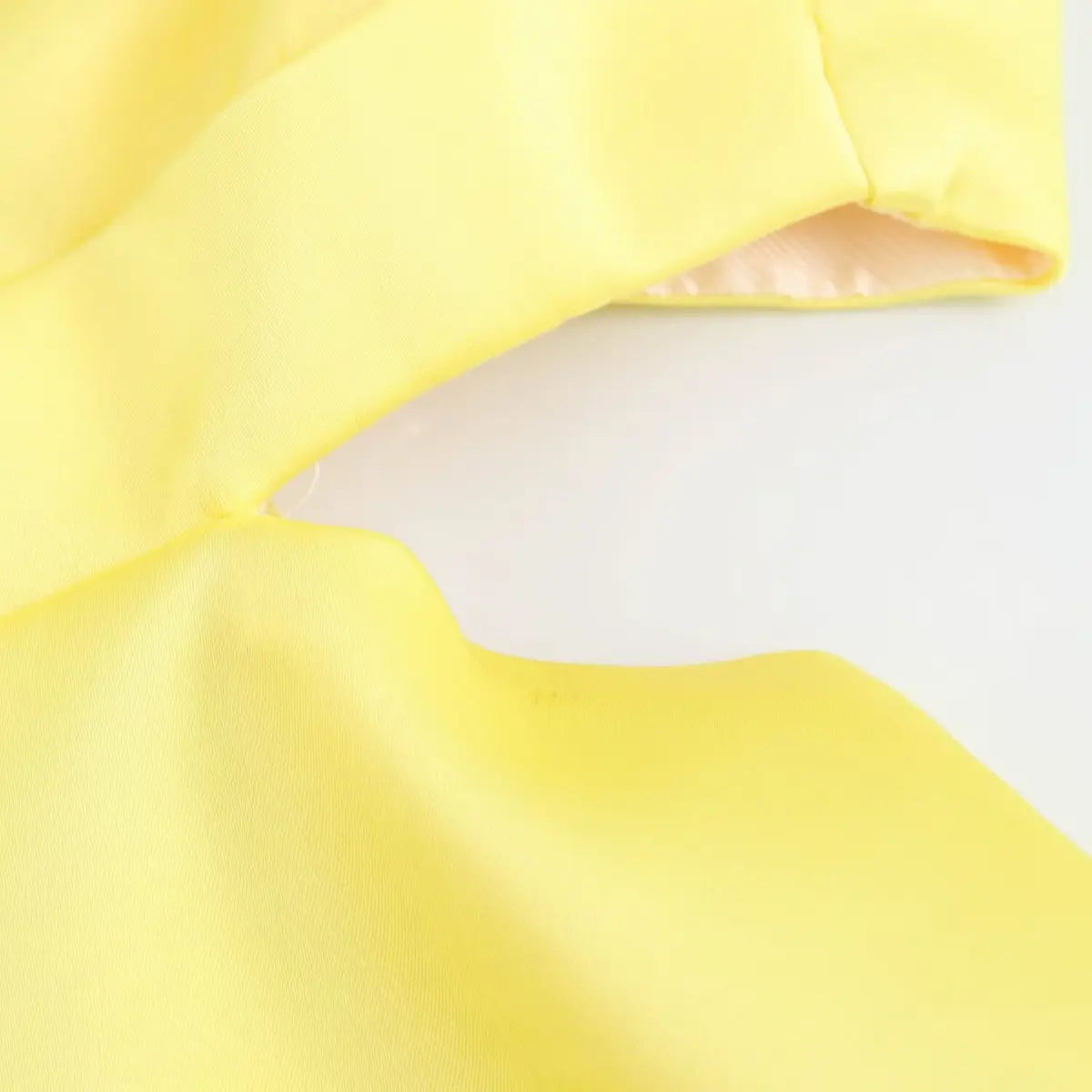  Close-up of the dress's waist cutout, highlighting the structured fabric and clean edges.
