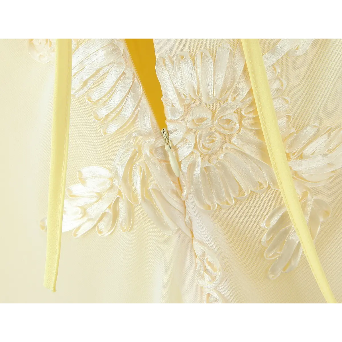 Close-up of the invisible side zipper, matching the pale yellow fabric and 3D floral embroidery.