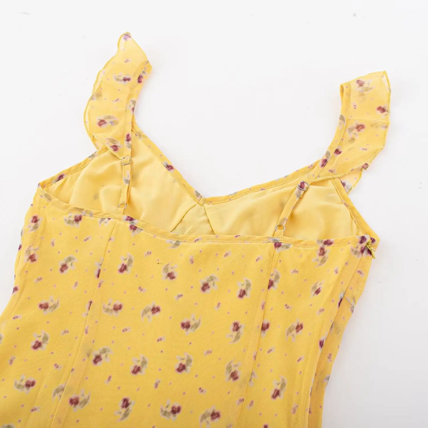 Top down interior back view, adjustable ruffle straps and fitted seam construction on yellow floral cami dress