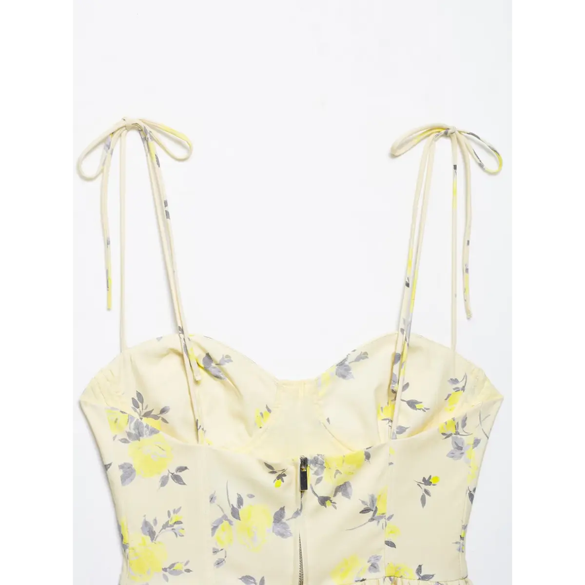 Partial back view showing the low-cut neckline and center zipper on yellow floral camisole
