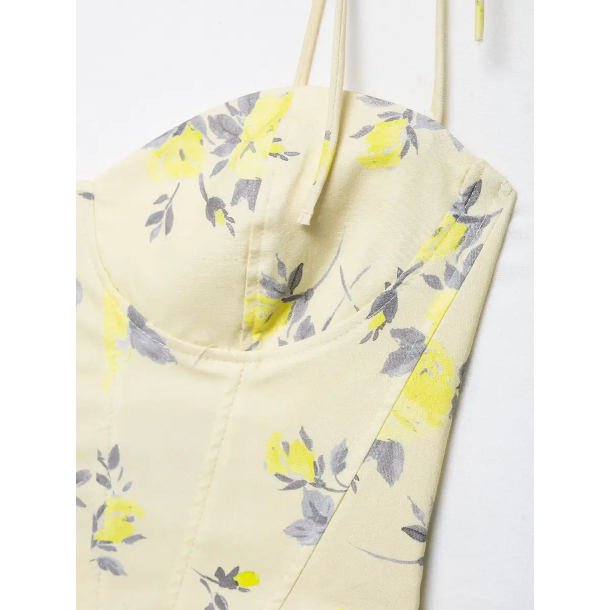 Close-up of the bust cup stitching and floral print on yellow corset camisole