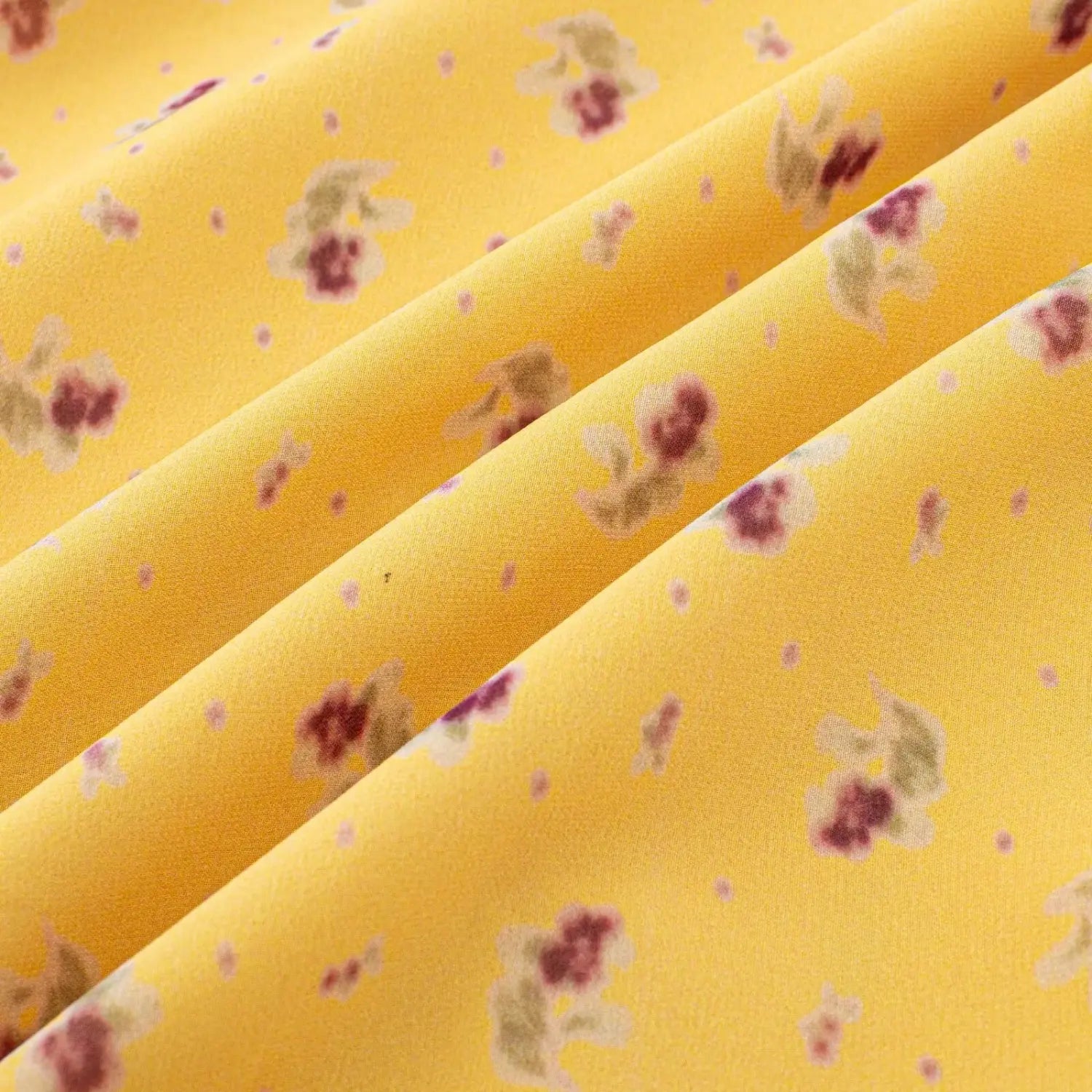 Folded fabric closeup shot, texture of yellow floral printed chiffon material for mini dress