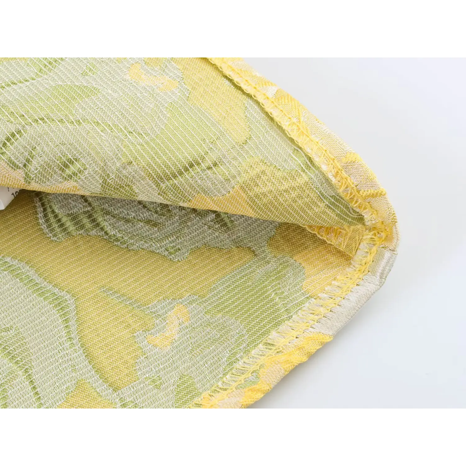 Macro close-up of dress hem finished stitching and embossed floral fabric texture