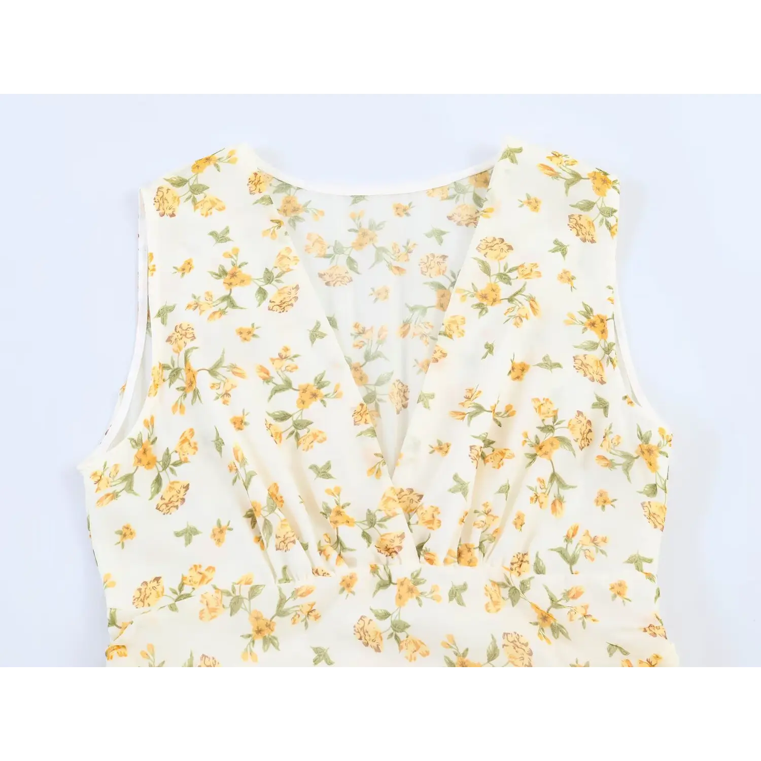 Close-up of deep v neckline and ruched bodice on cream yellow floral sleeveless dress