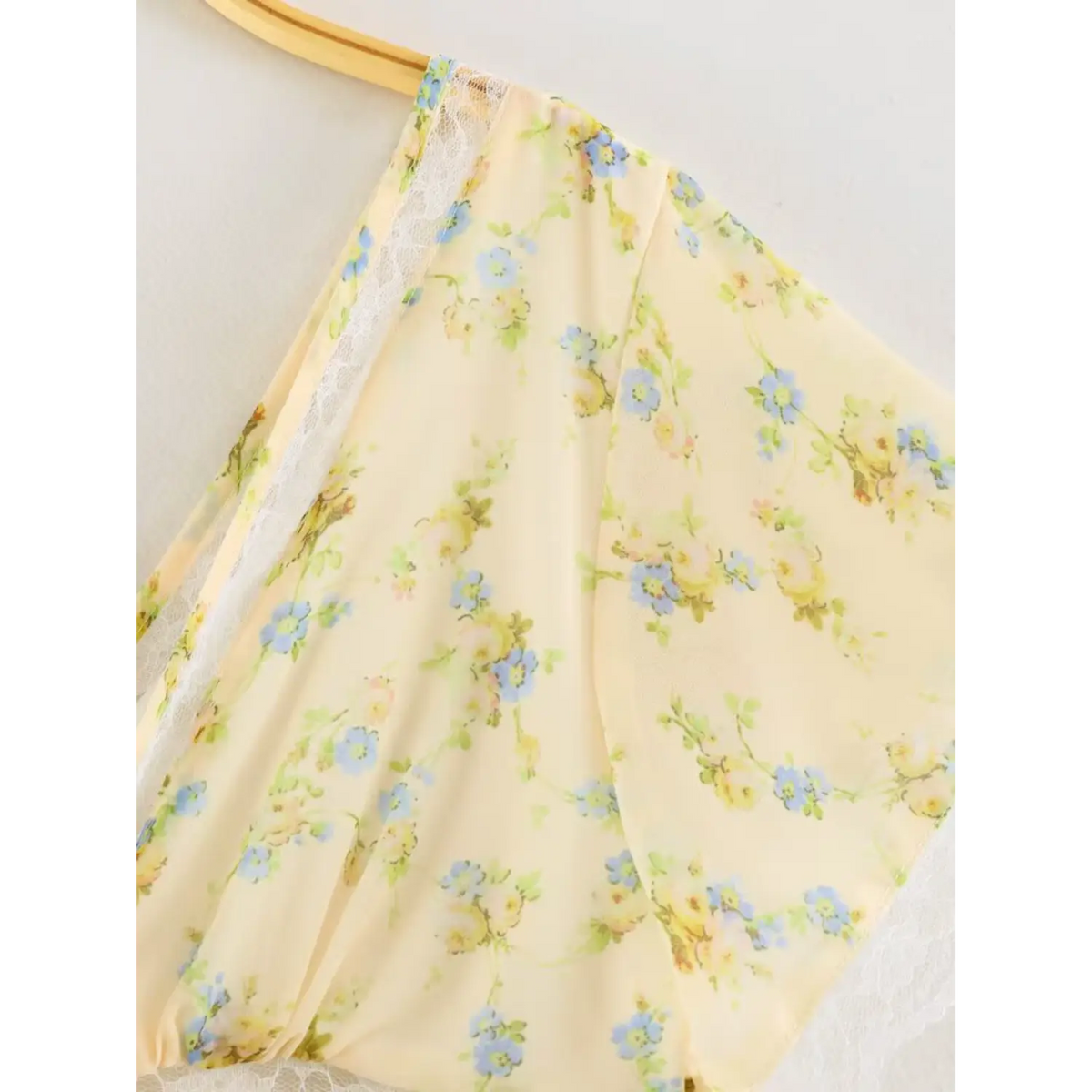 Partial shot of flutter short sleeve, yellow floral chiffon with white lace scalloped edge