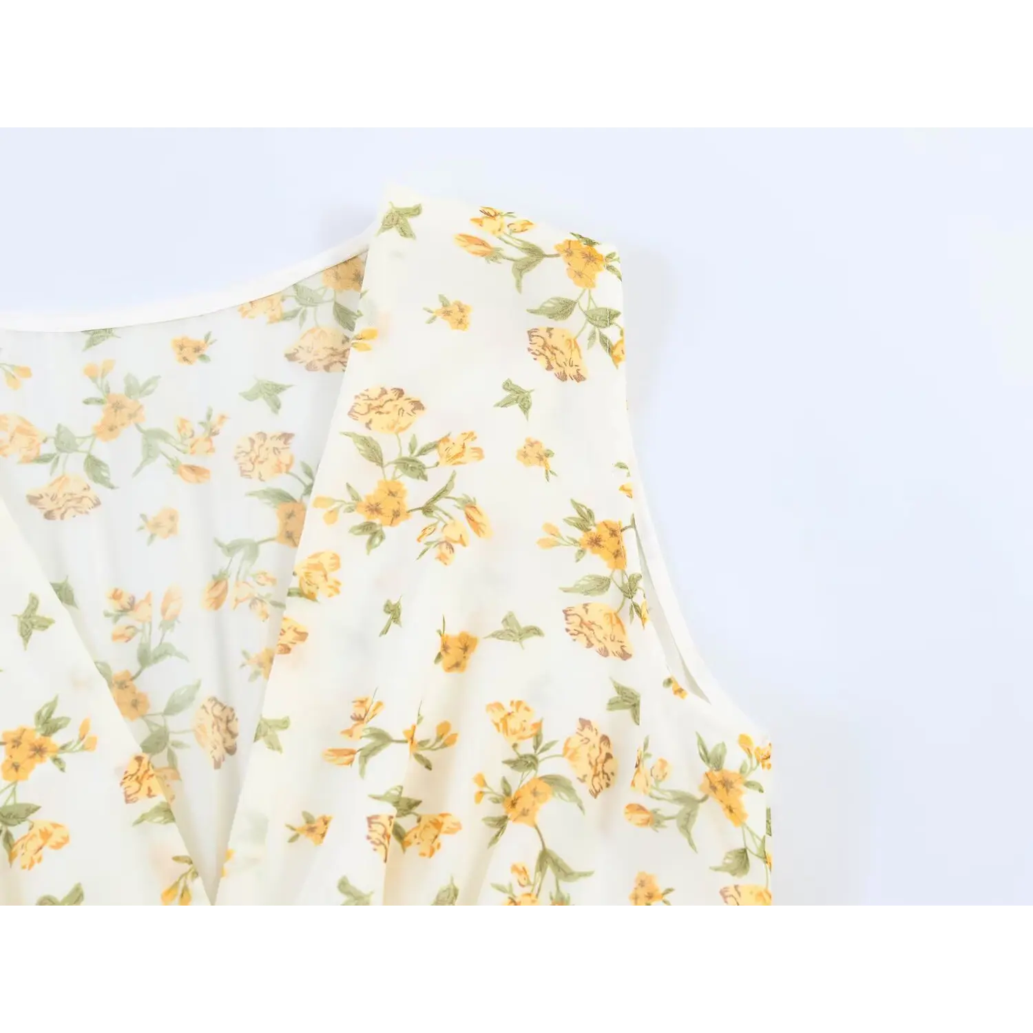 Detail shot of sleeveless armhole and floral printed chiffon fabric