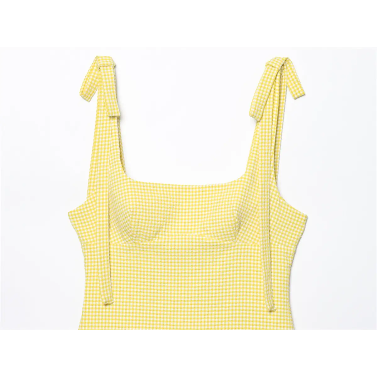 Front view of yellow gingham dress, highlighting the square neckline, bust darts, and tied bow straps