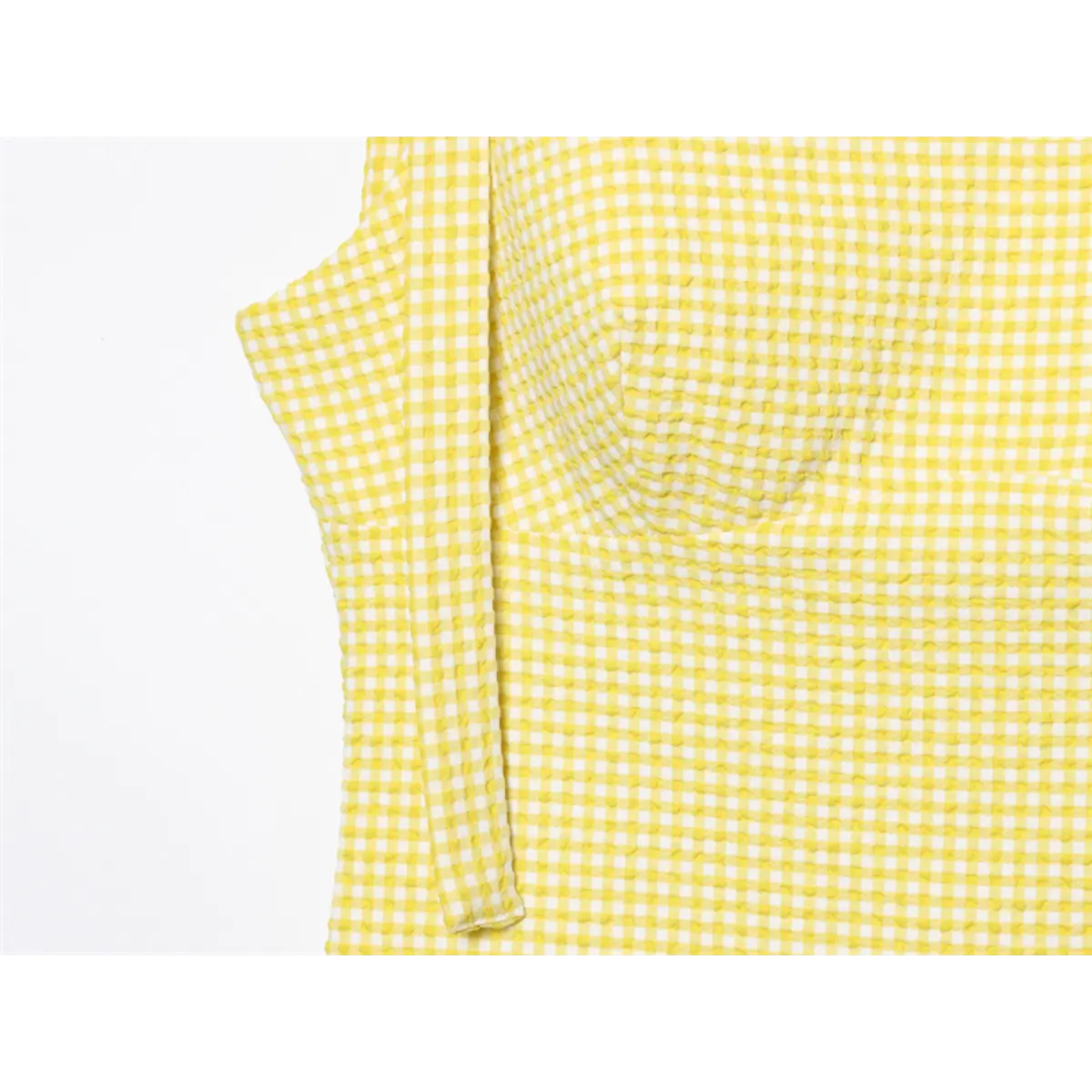 Side view of yellow gingham dress, showing the bust darts and textured fabric