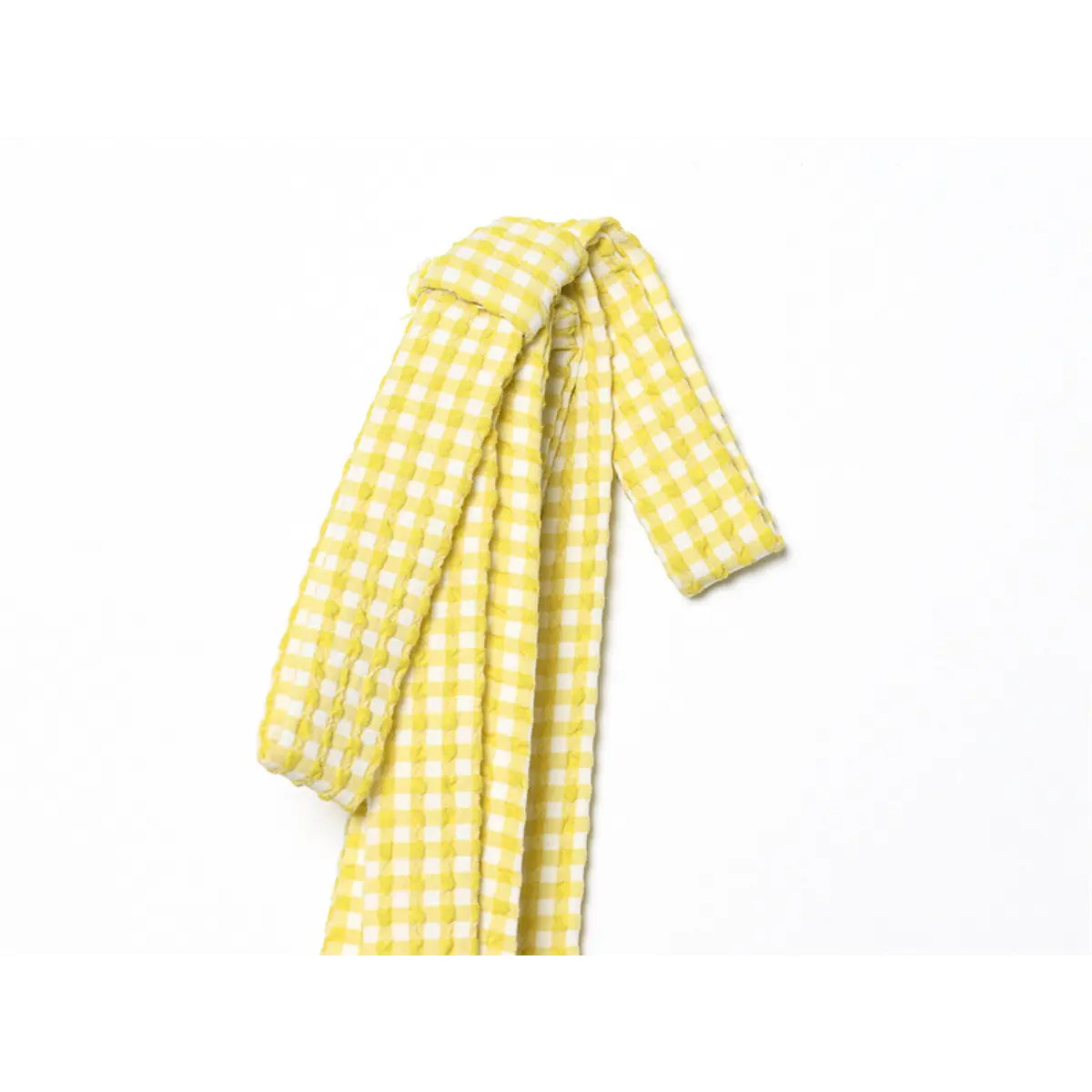 Close-up of the tied bow strap on the yellow gingham dress, showing the textured fabric and knot detail
