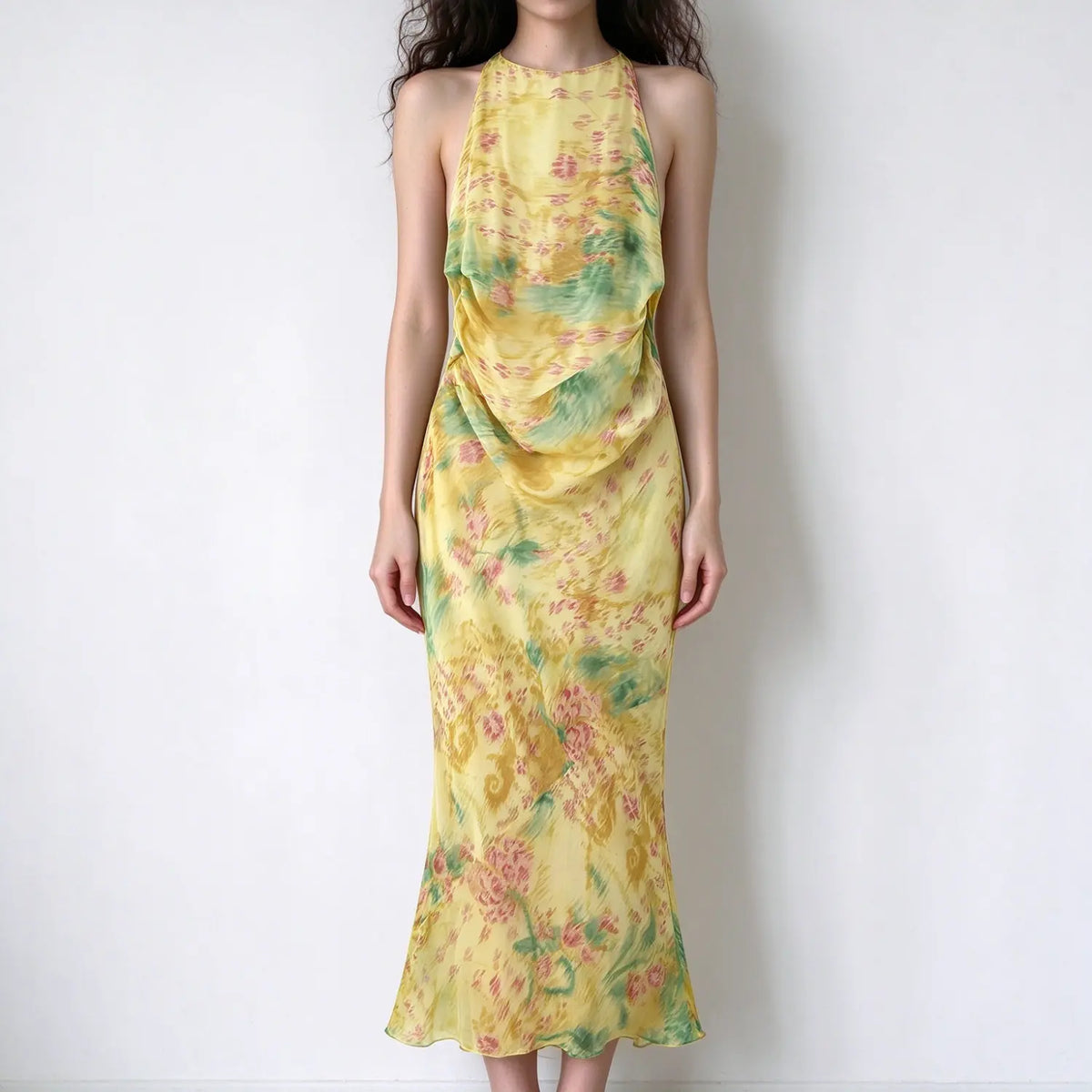 Model wearing yellow green watercolor print halter maxi mermaid dress, draped chest detail, slim fit, flared mermaid hem
