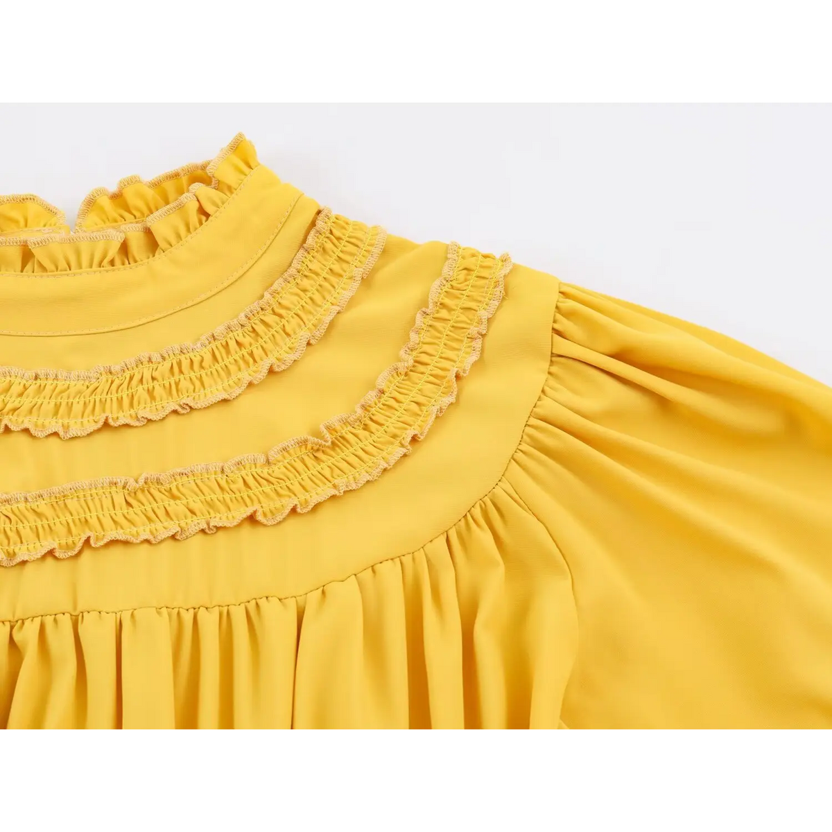 Close-up of ruffle trimmed collar and gathered puff sleeve on yellow maxi dress