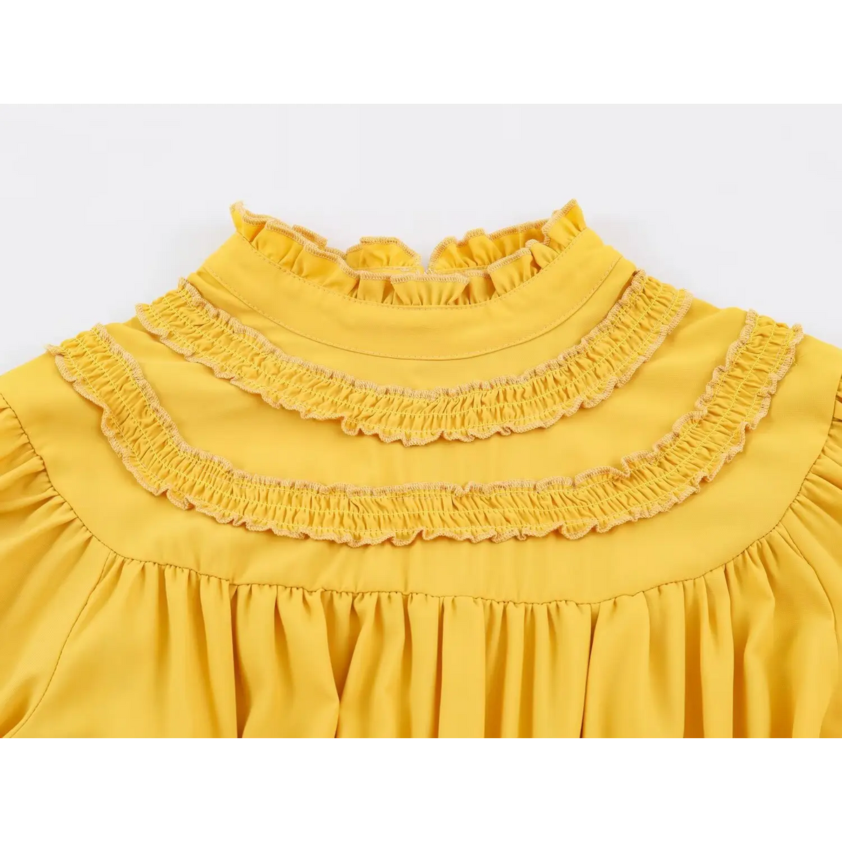 Close-up of layered ruffle collar and gathered shoulder on yellow dress