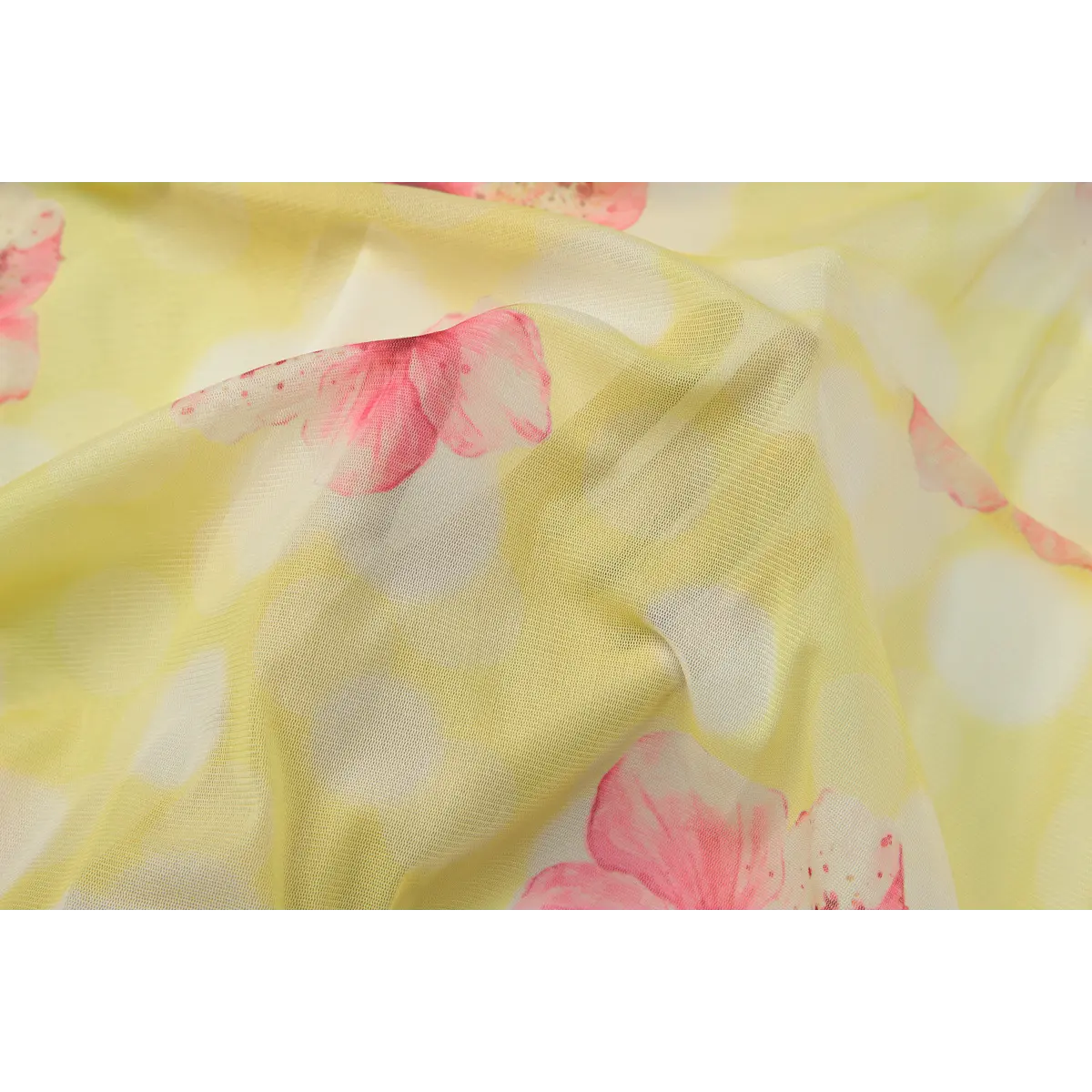 Macro view of yellow mesh fabric with a pink hibiscus floral print, highlighting the texture and print details.