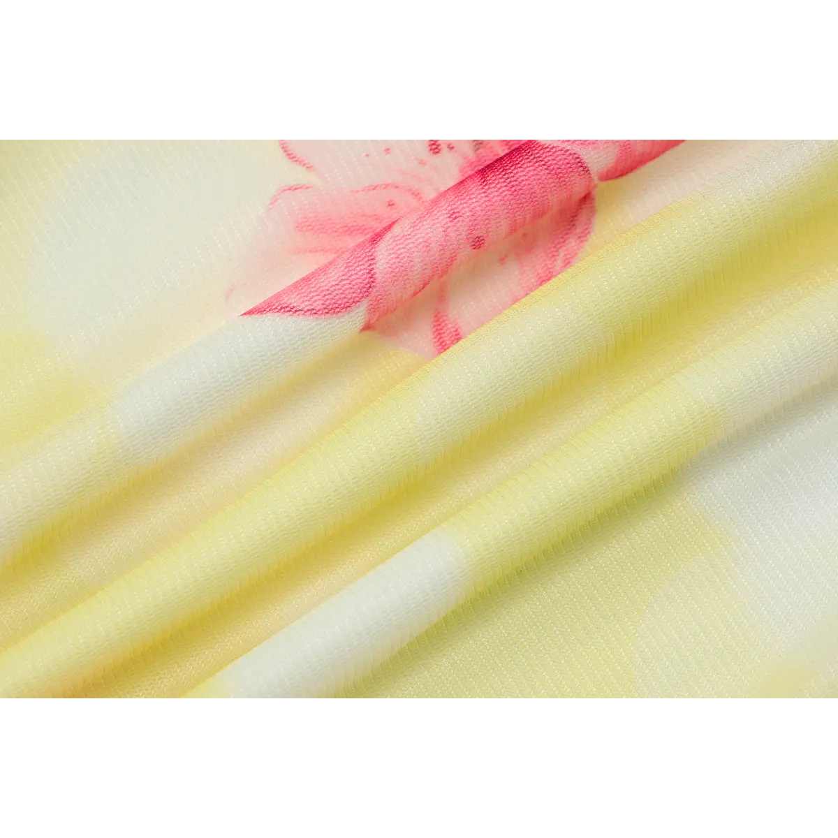 Close-up shot of yellow mesh fabric with a pink hibiscus floral print, showing the sheer texture and gradient color.