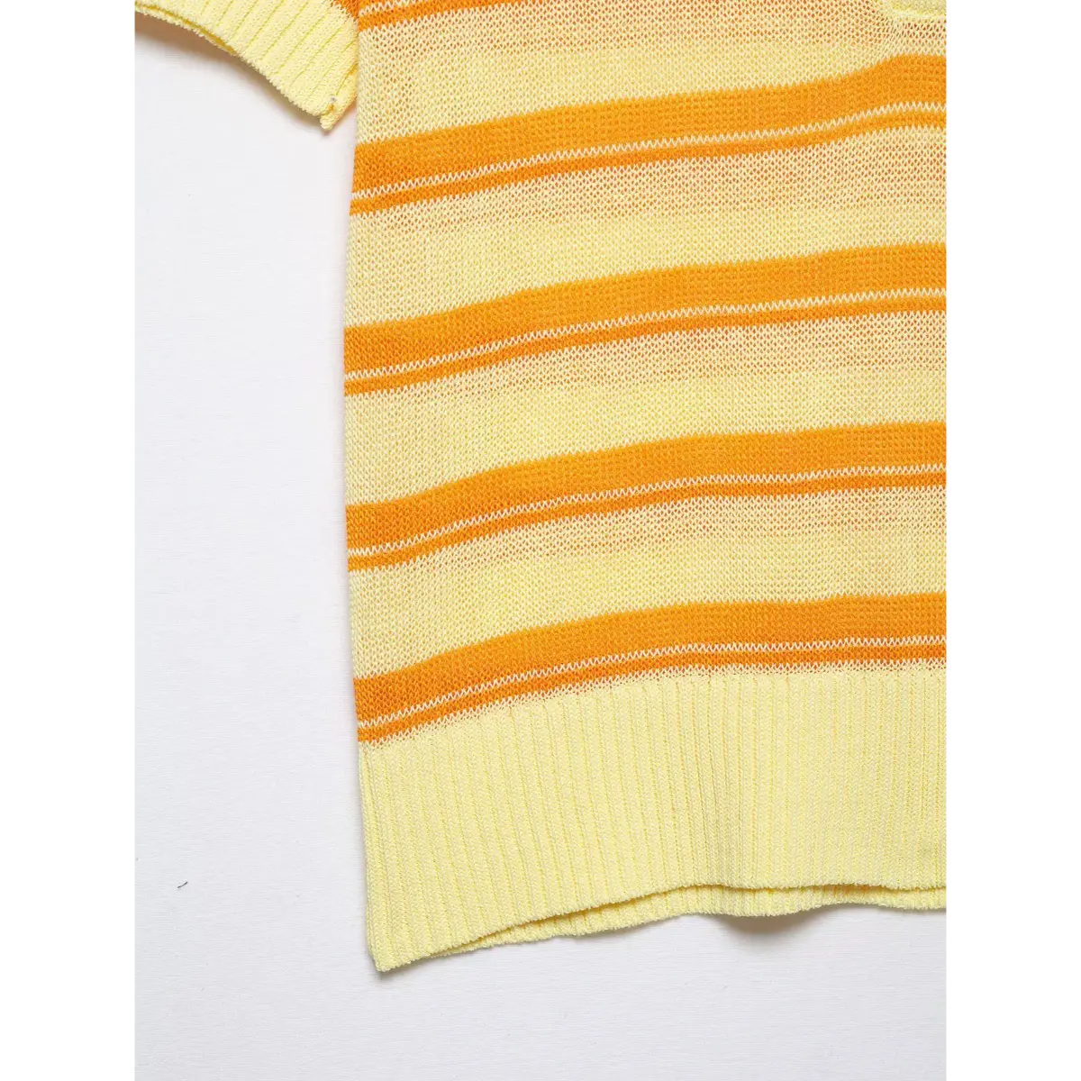 Close-up detail of a yellow and orange striped knit polo top, showing the mesh fabric texture, ribbed hem, and short sleeve cuff.