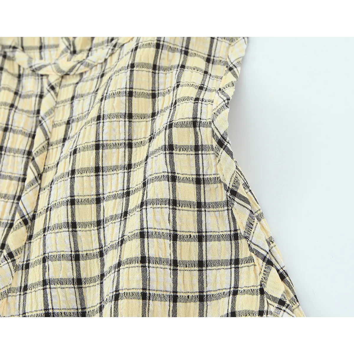 Side detail of the yellow plaid camisole, highlighting the ruffled seam and plaid pattern