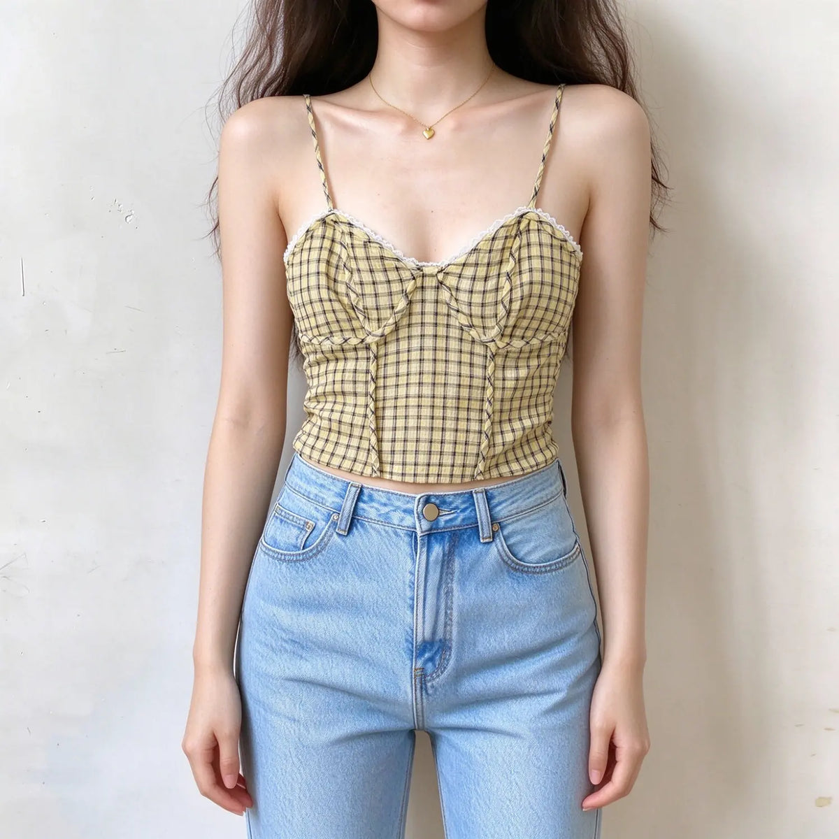 Model wearing yellow plaid camisole top, thin twisted straps, lace trim at bust, corset seamed design, cropped fitted style