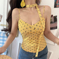 Model front close‑up yellow black polka dot v‑neck cami top with detachable halter tie strap fitted waist