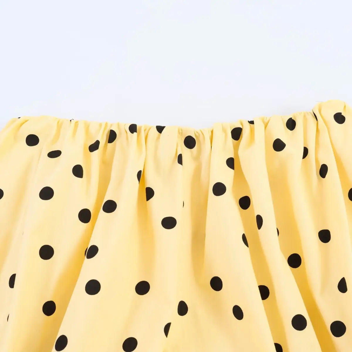 Close-up of the black polka dot pattern on the yellow fabric