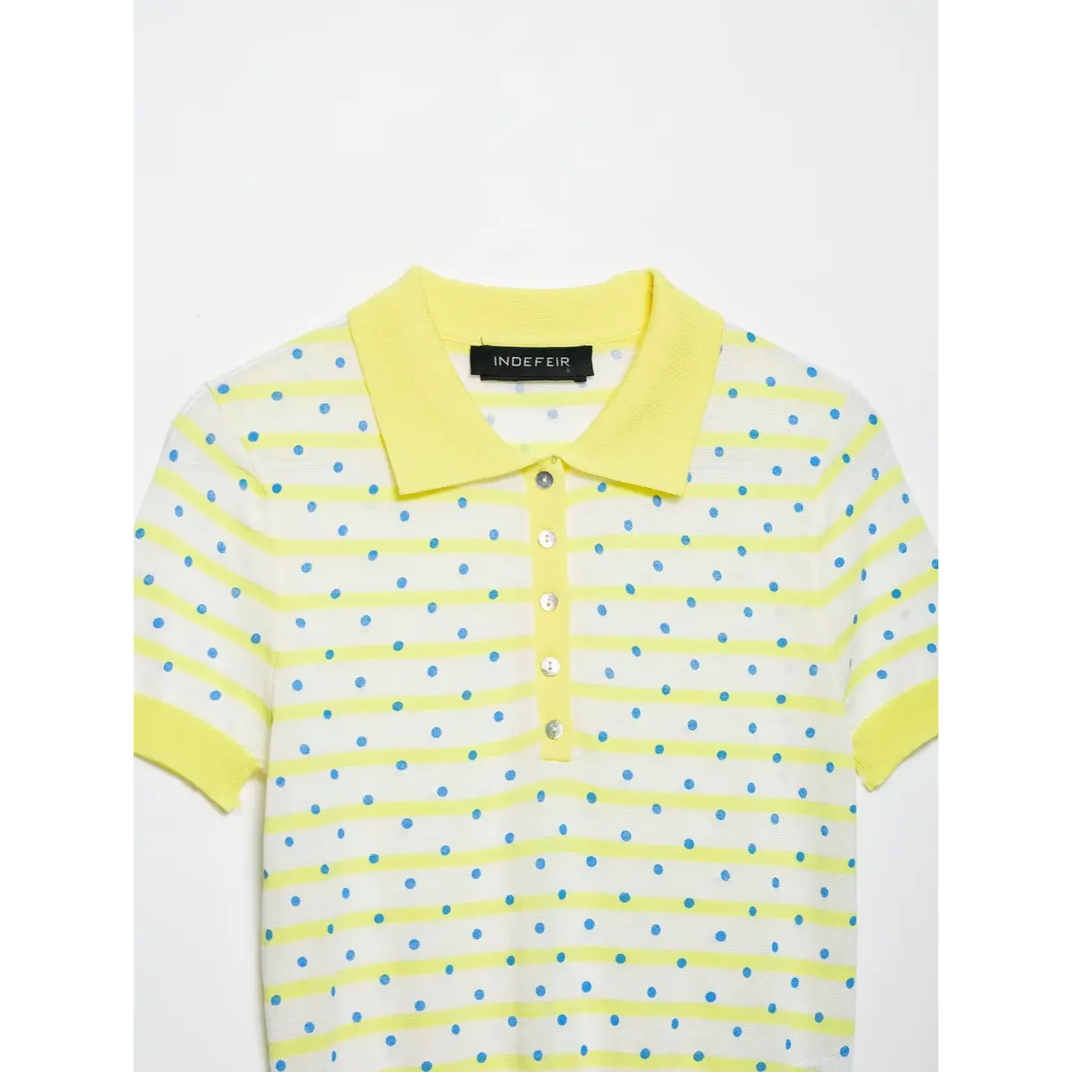 Close-up of the front placket on a yellow and white polka dot knit polo shirt, showing the row of mother-of-pearl buttons and the striped pattern.