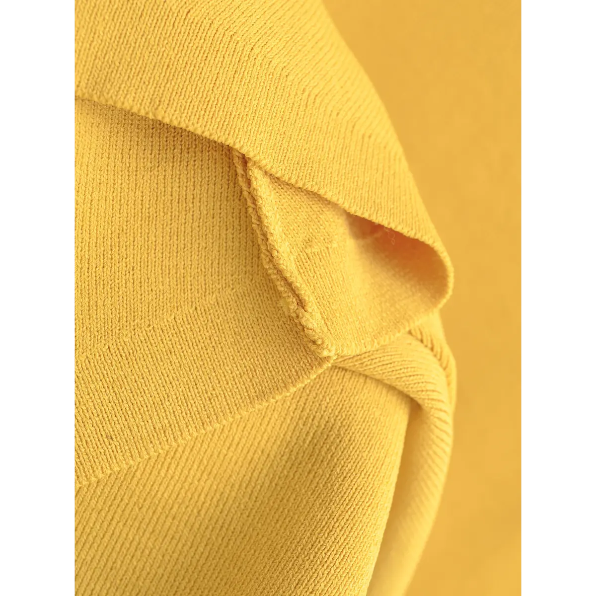 Close-up of the fine knit texture, showcasing the soft and stretchy construction of the yellow fabric.
