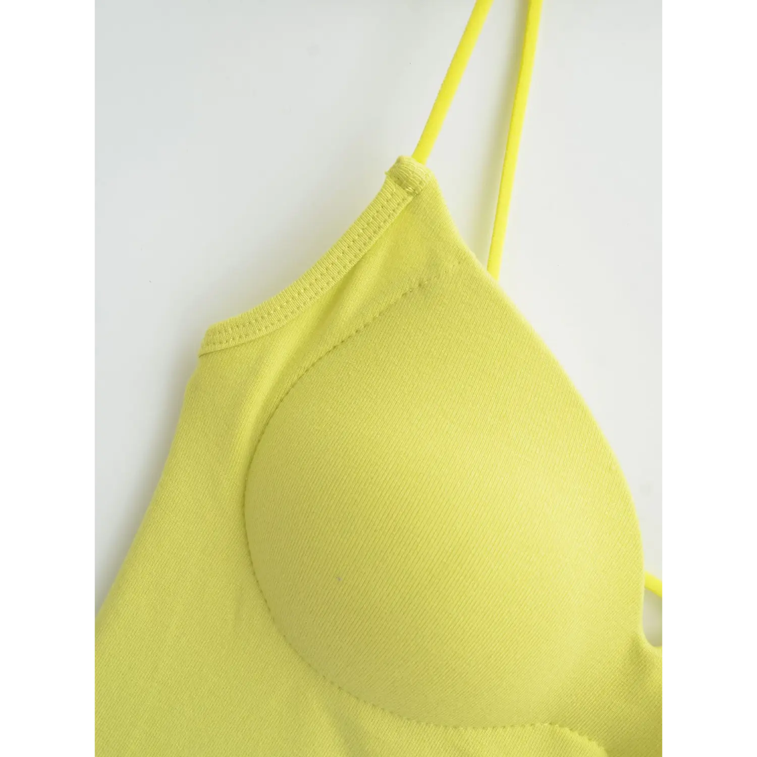 Yellow camisole thin strap root flat close-up, ultra thin elastic straps double binding overlock v neck neat stitching white background craft shot