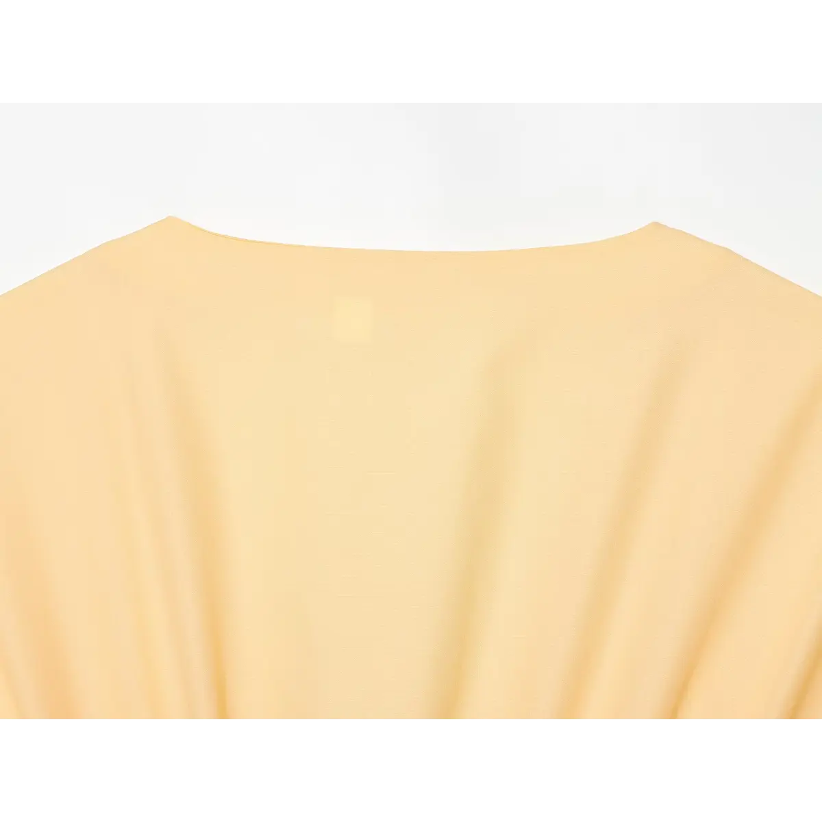 Top view of the dress's back, showing the smooth fabric and shoulder seam.