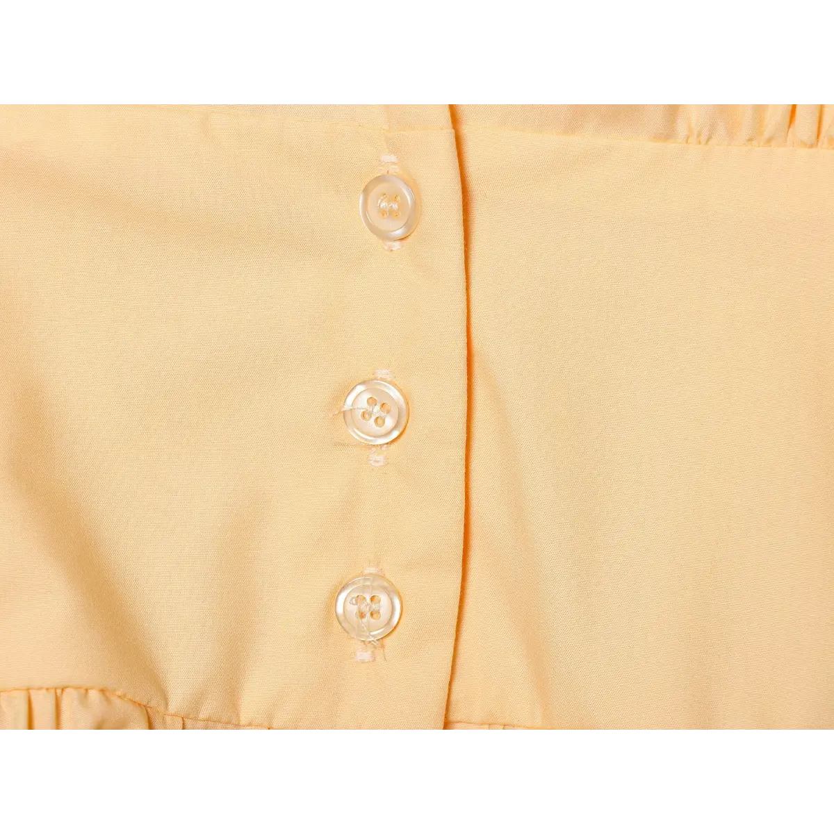 Close-up of the dress's front placket, showing the light-colored buttons and stitching.