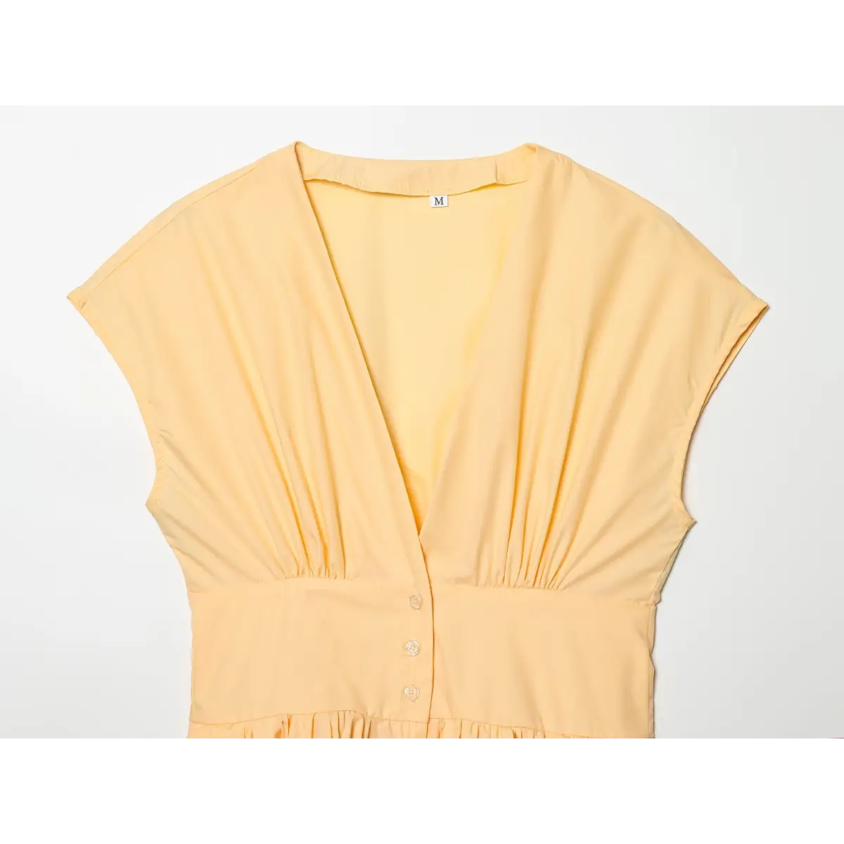 Top view of the dress, showing the full V-neckline, cap sleeves, and button placket.