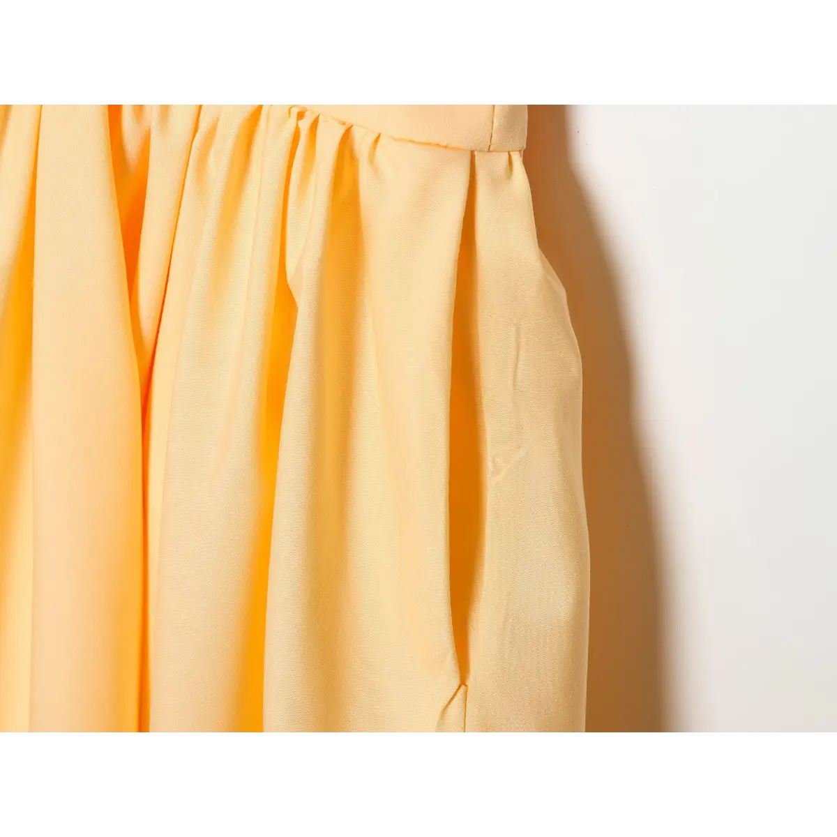 Close-up of the dress's gathered waist and flared skirt fabric.