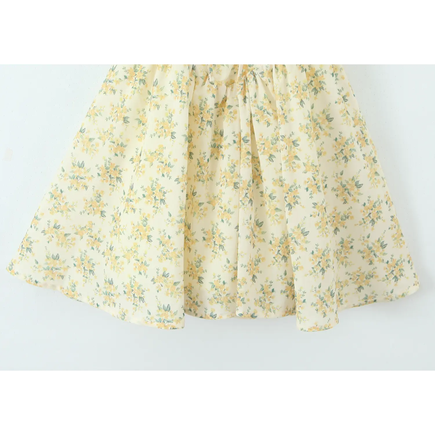Full hem view of flowy flared skirt for yellow floral halter mini dress
