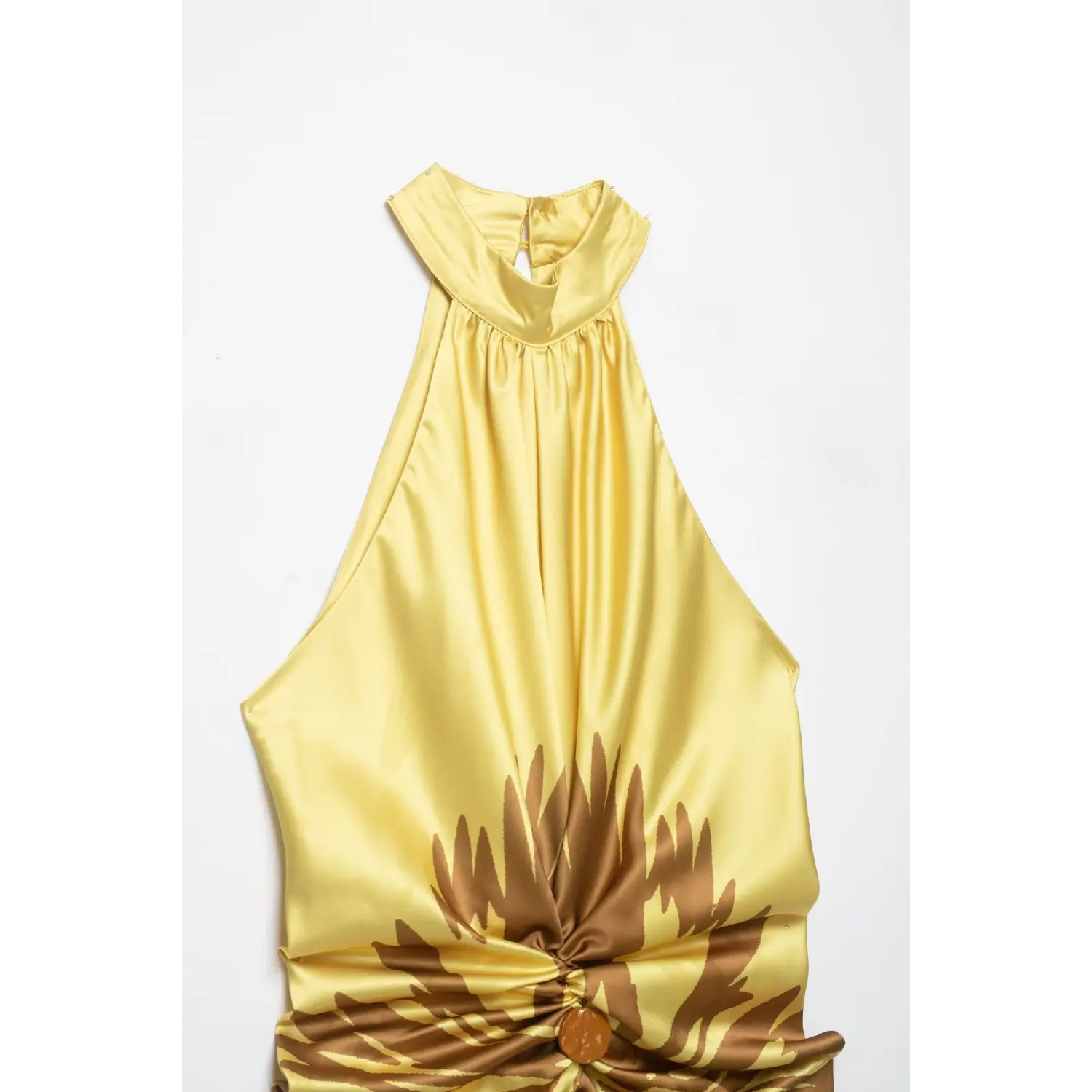 Close‑up shot of yellow satin halter maxi dress, showing halter neck gathering and front waist twist knot with decorative button