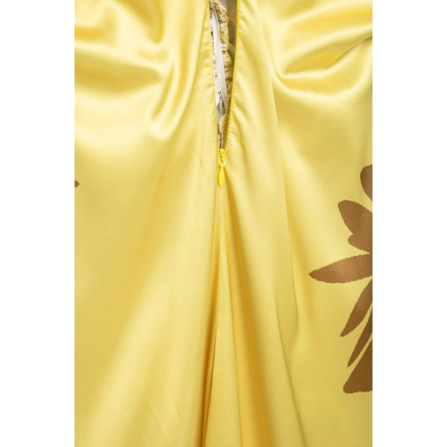 Close‑up of invisible back zipper inner lining on yellow satin halter maxi dress, showing fabric stitching workmanship