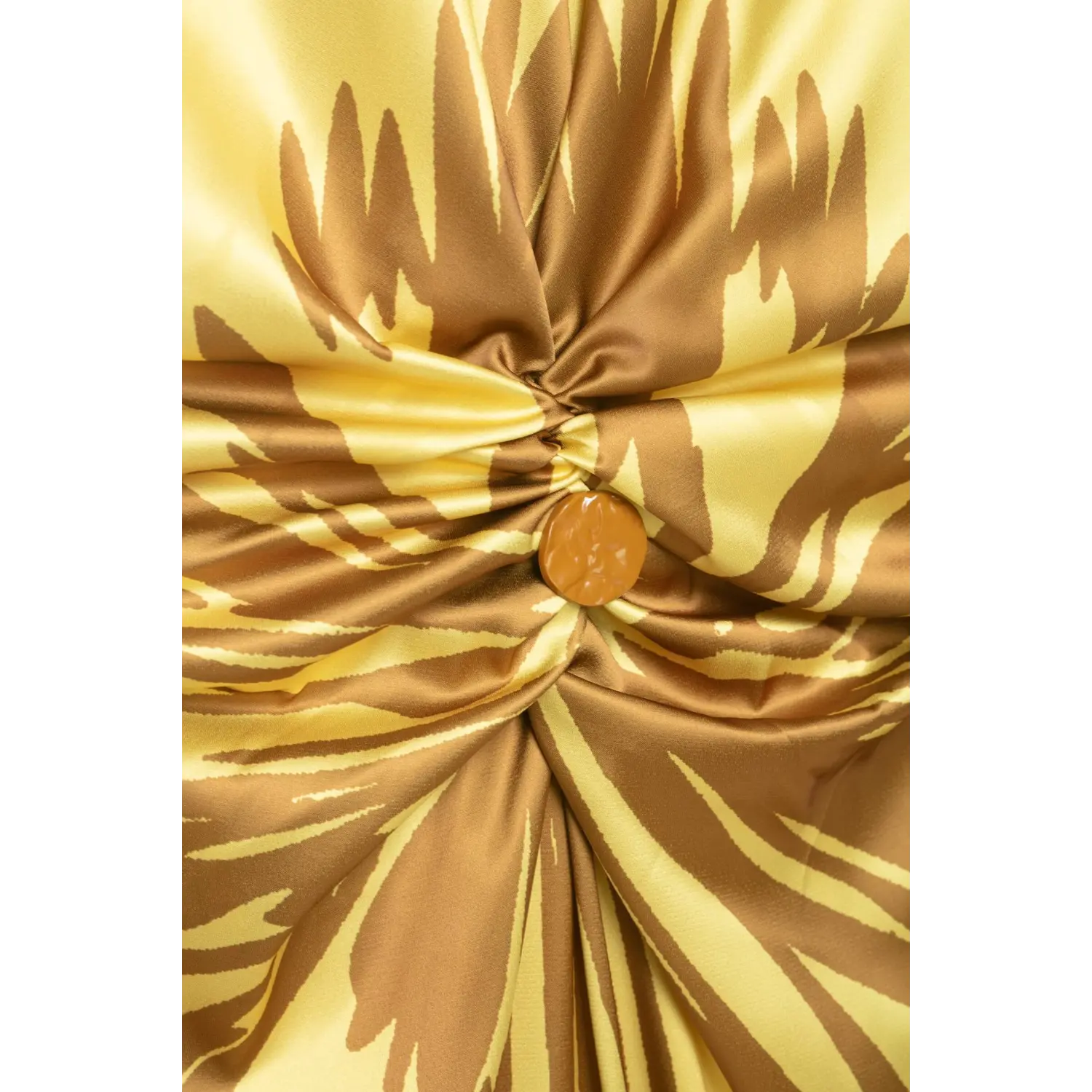 Macro close‑up of front waist twist knot and round decorative button on yellow brown floral satin halter maxi dress