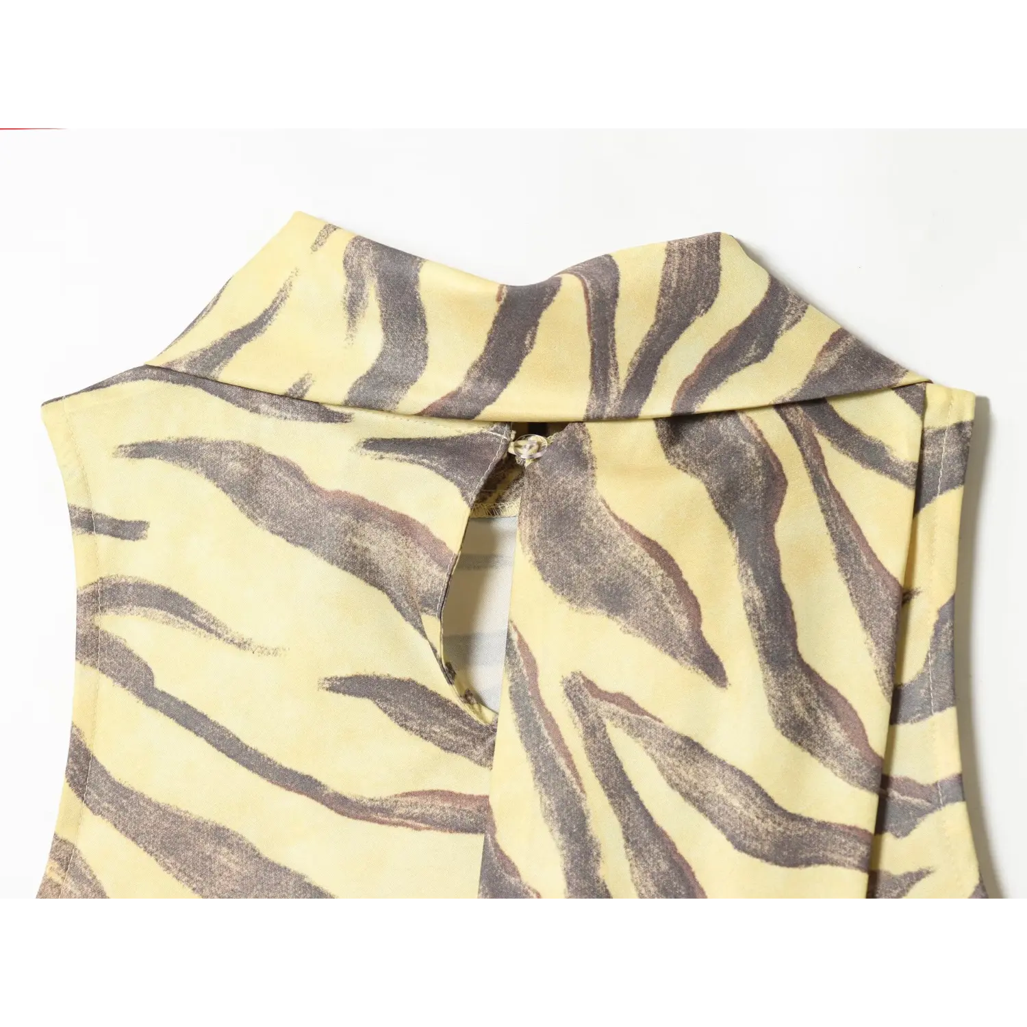 Back partial shot, keyhole cutout at cowl neck back, fabric sash overlay on yellow zebra print dress