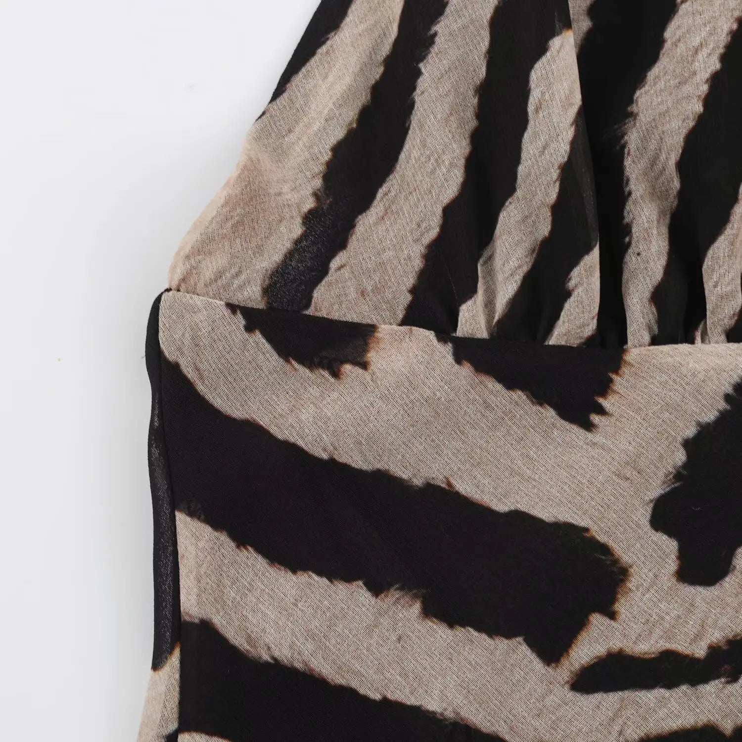 Close‑up side bust detail of zebra print chiffon maxi dress, fabric and stitching view