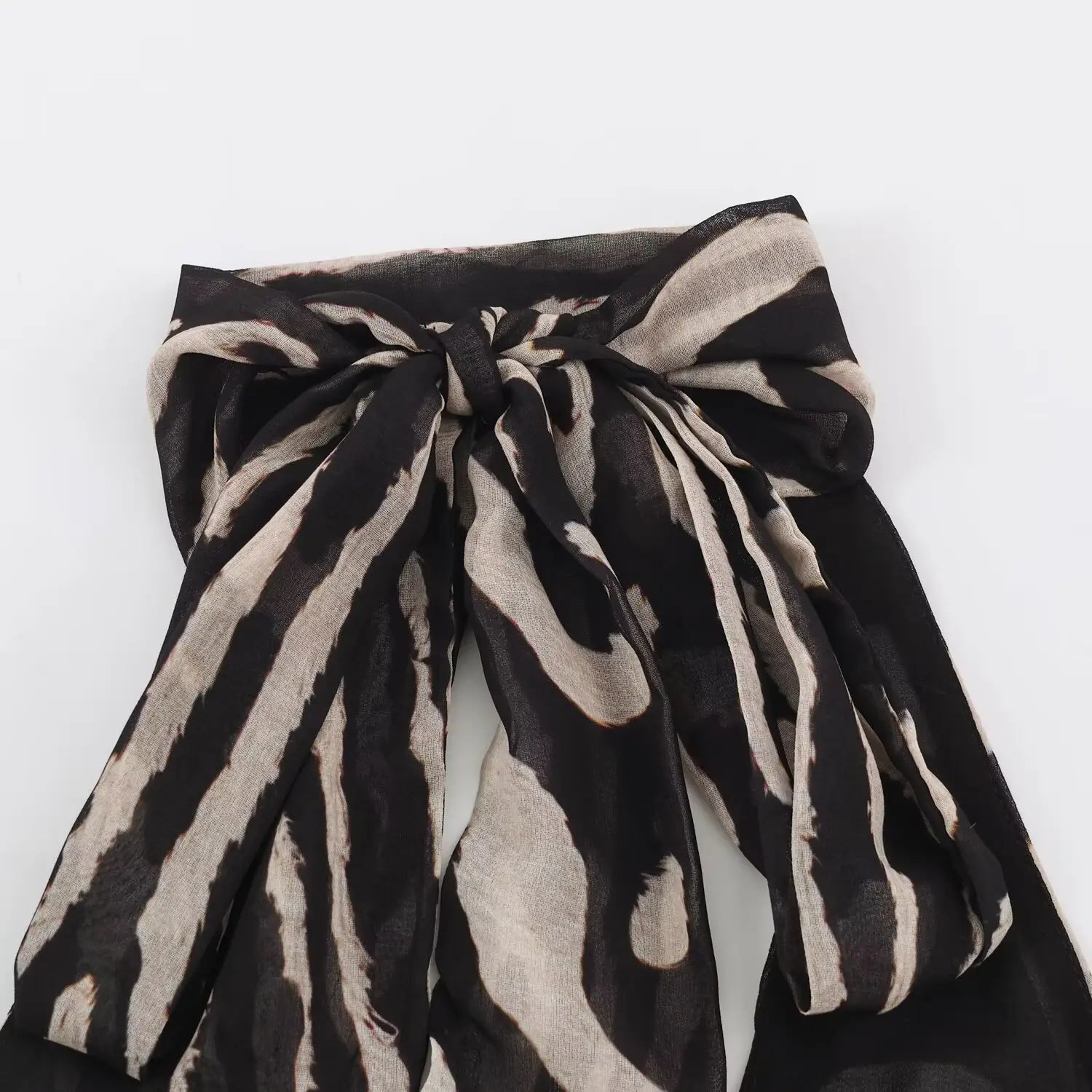 Macro close‑up of large halter neck bow knot on zebra print chiffon maxi dress, show fabric print and bow detail