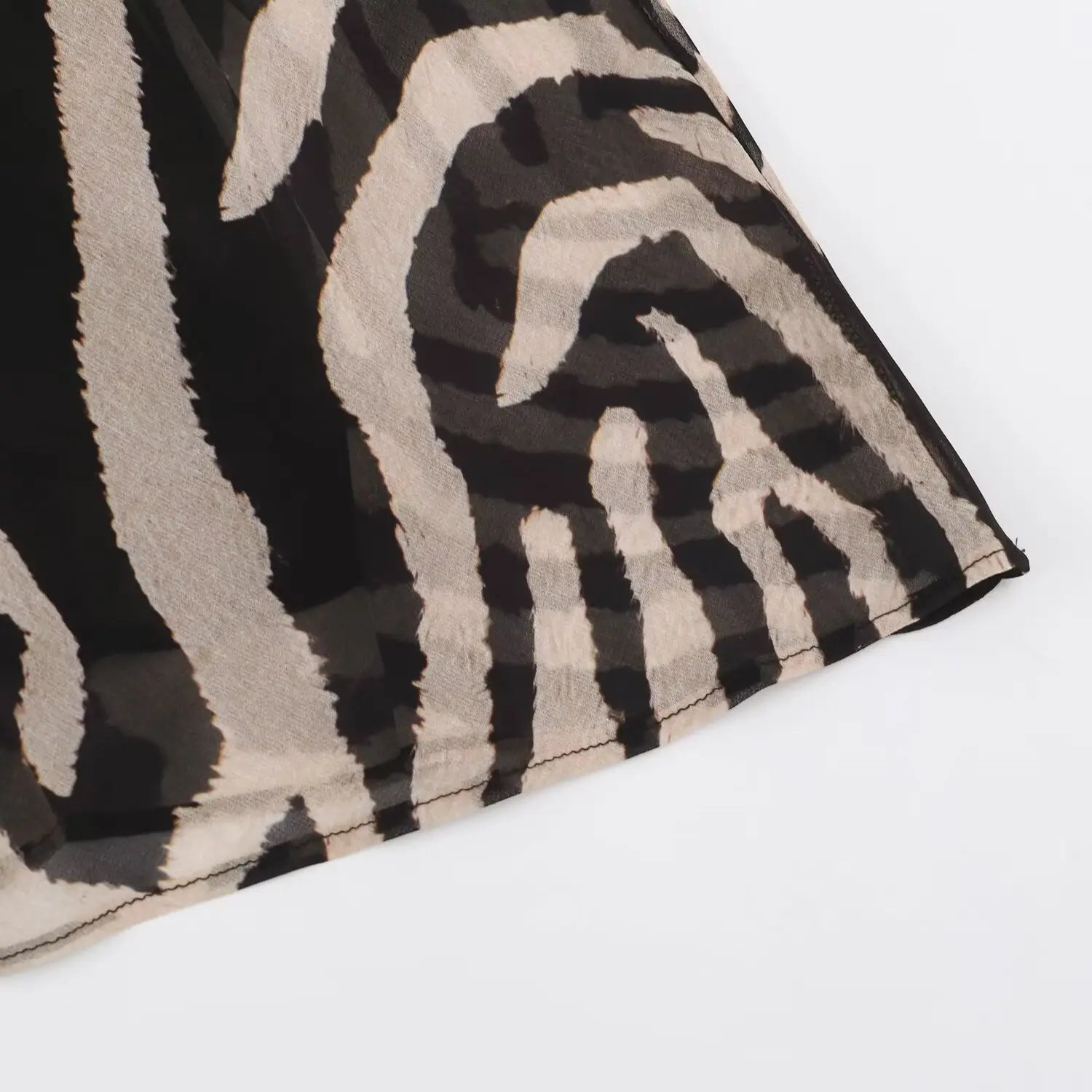 Macro shot of finished hem stitching on zebra print maxi chiffon dress