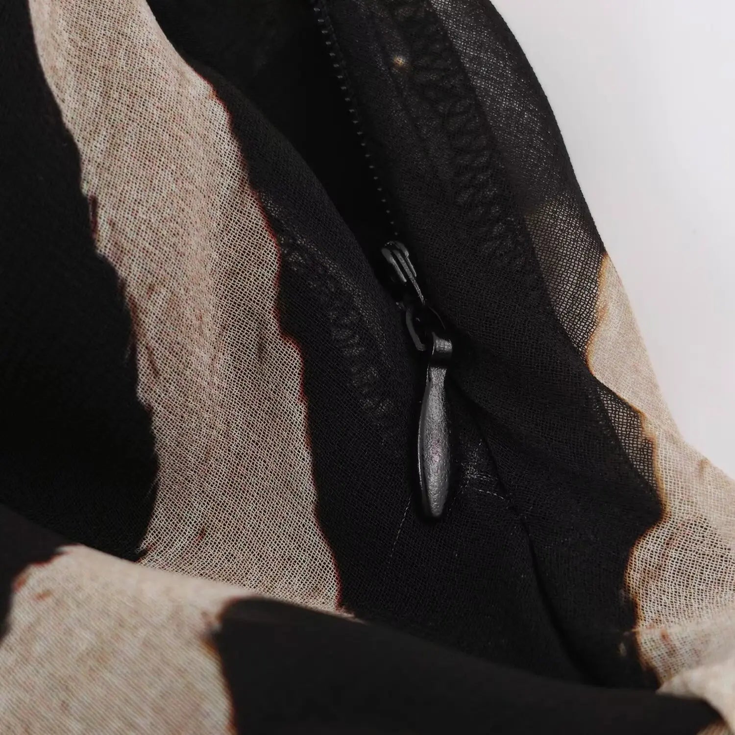 Close‑up of invisible side zipper on zebra print halter maxi dress, inner lining view