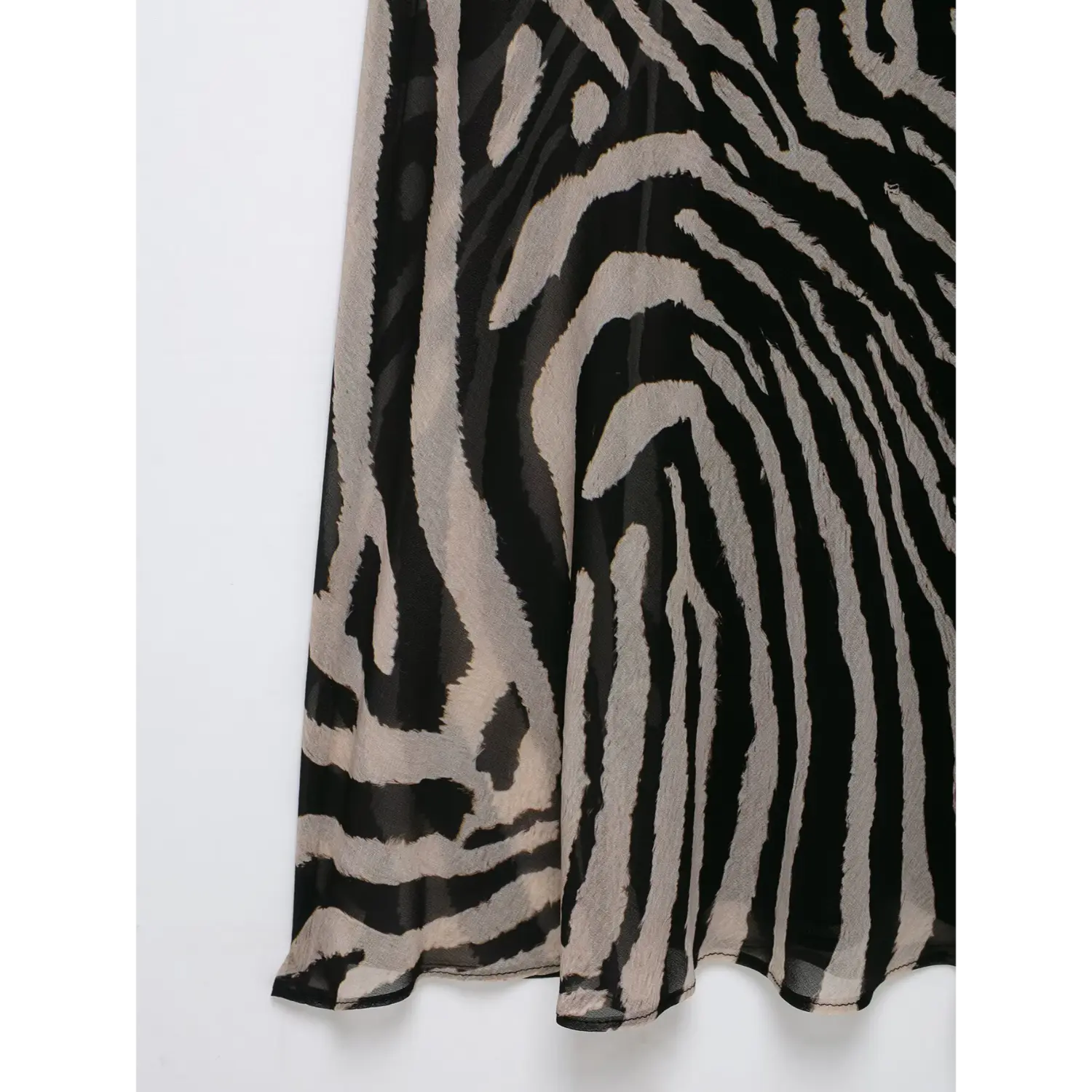 Close‑up flared skirt hem and lightweight sheer fabric of zebra print halter maxi dress