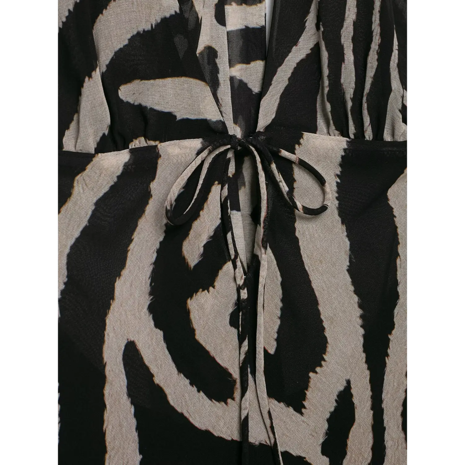 Extreme close‑up front waist drawstring tie detail on zebra printed halter maxi dress